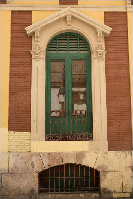 Las ventanas tena arco de medio punto, cornisa y falsas columnas con barandilla de hierro forjado.